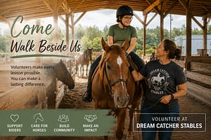 Adaptive riding volunteer walking beside a rider and horse at Dream Catcher Stables